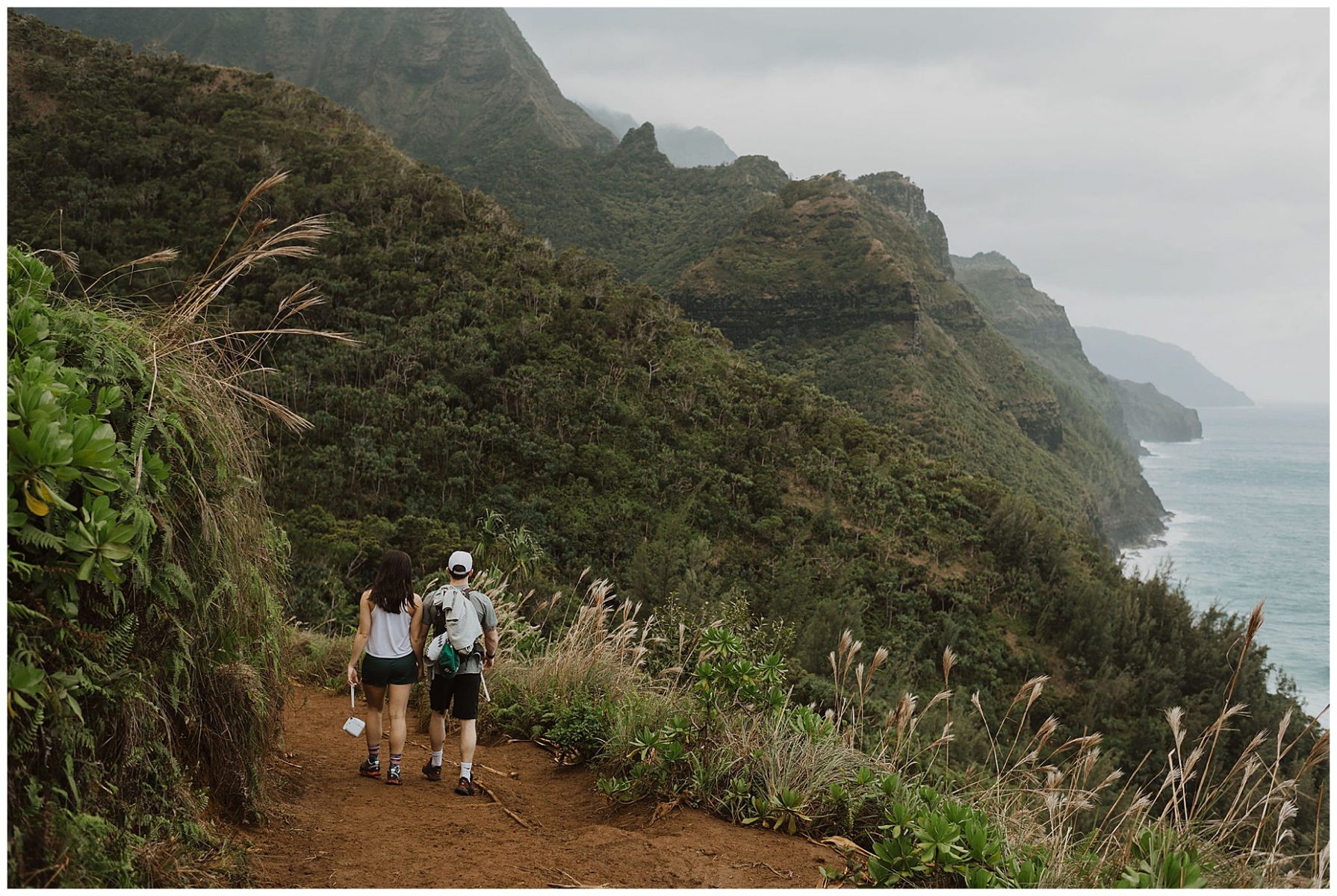 bride and groom hiking during their adventurous elopement on the cliffs of Waimea Canyon in Kauai, Hawaii 