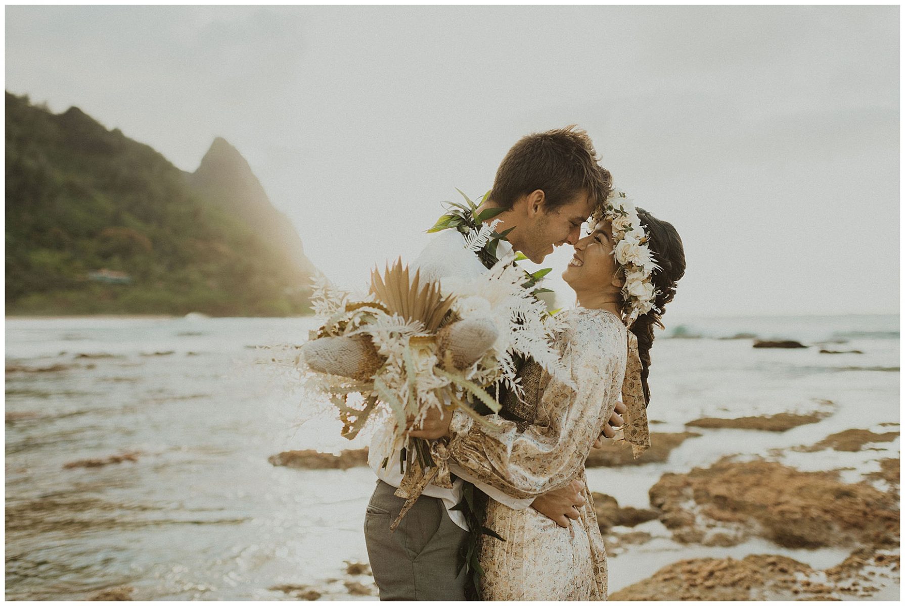 bride dressed in a gold dress holding hands with her groom, dressed in Hawaiian attire during their elopement on the beach of Kauai