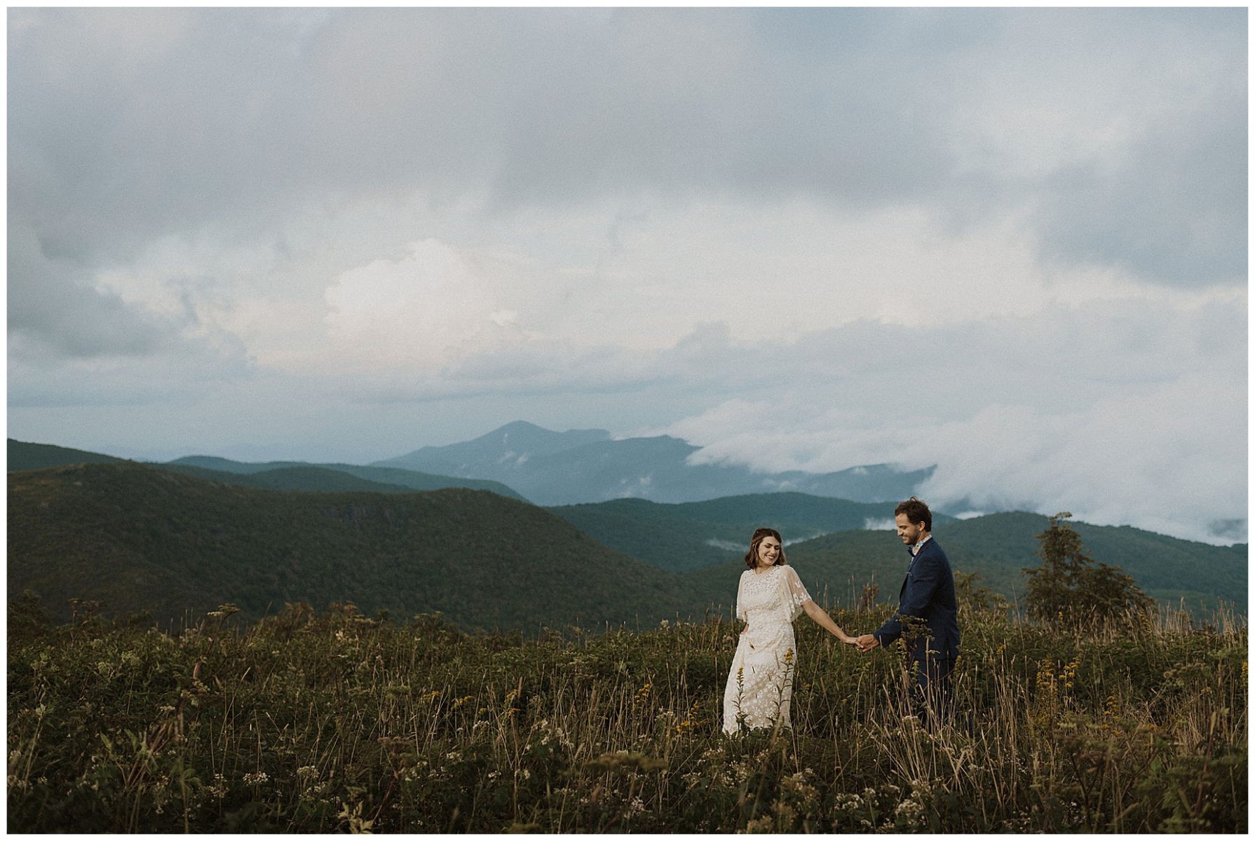 bride and groom holding hands, walking through the wildflowers on their elopement day